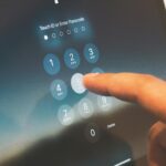 Close-up of a finger entering a passcode on a smartphone security screen.