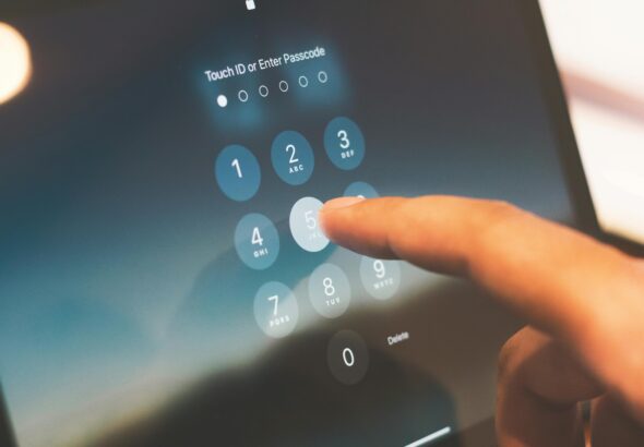 Close-up of a finger entering a passcode on a smartphone security screen.