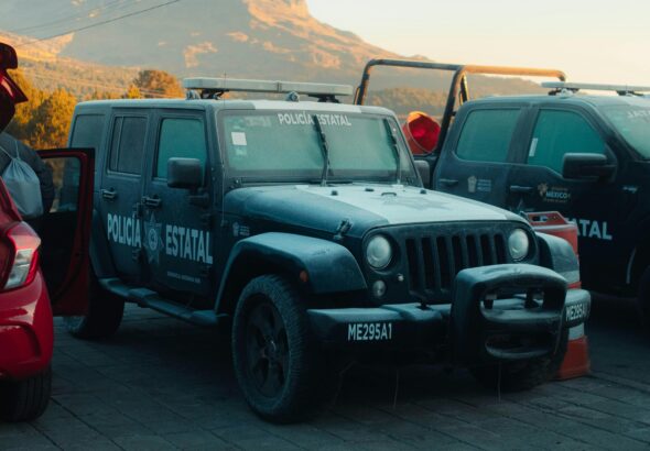 A State Police Jeep parked outdoors with a scenic mountain view in the background.