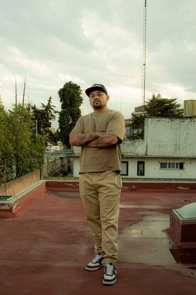 Man standing confidently on a rooftop in Mexico City, urban vibe.