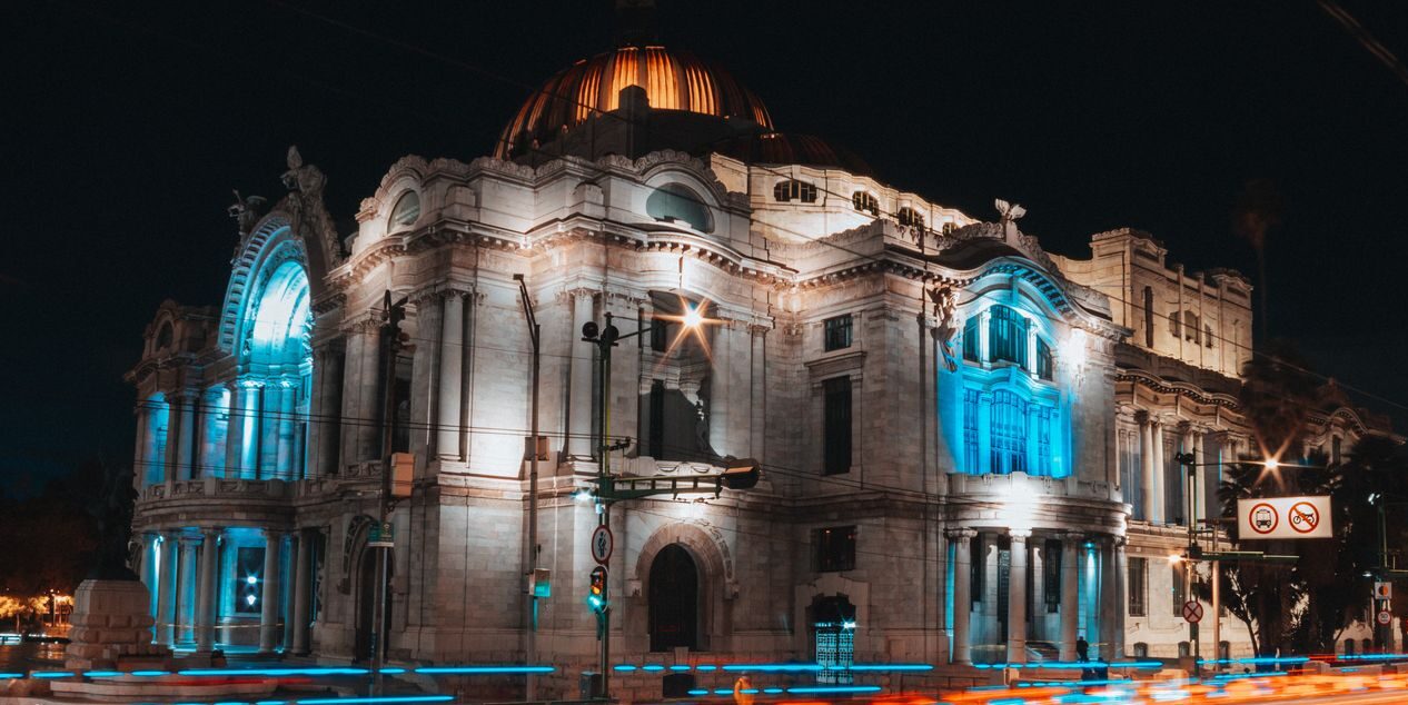 Night view of the illuminated Palacio de Bellas Artes with light trails in Mexico City.
